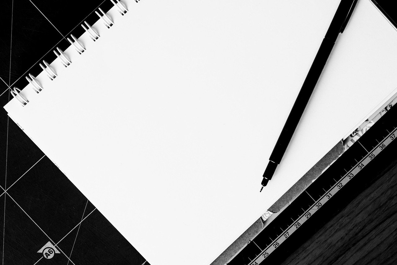 A blank notebook and pen resting on a desk, ready for planning.