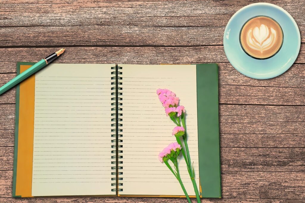 An open journal notebook filled with handwritten pages, resting on a wooden surface.