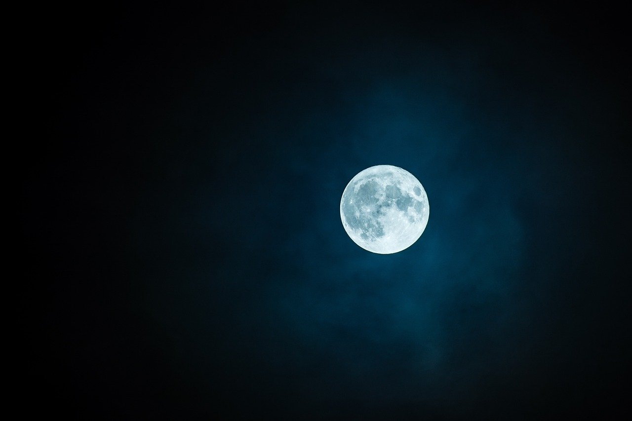 A full moon glowing in a dark night sky
